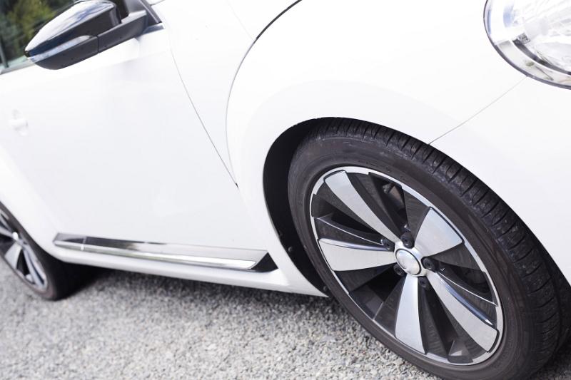 Free Stock Photo: Angled close up on side of white sports automobile with complementary black and chrome hubcaps