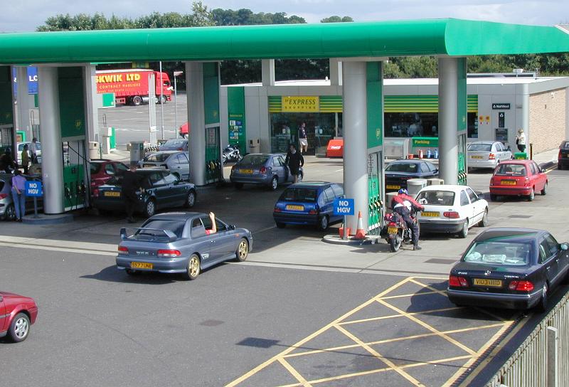 Free Stock Photo: Motorists waiting for petrol or gas in a forecourt of a modern service station with people filling their cars at the pumps