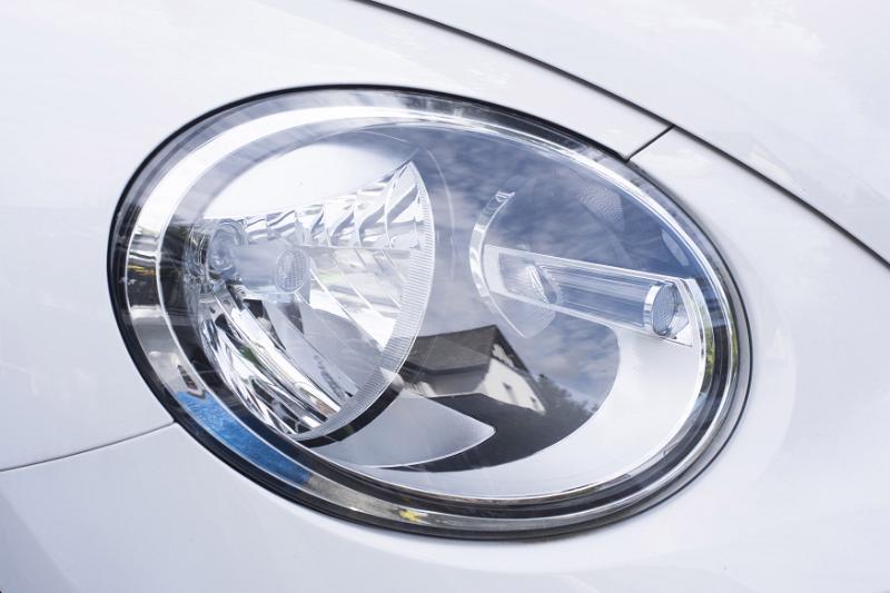Free Stock Photo: Modern oval car headlamp on a white car in a close up view