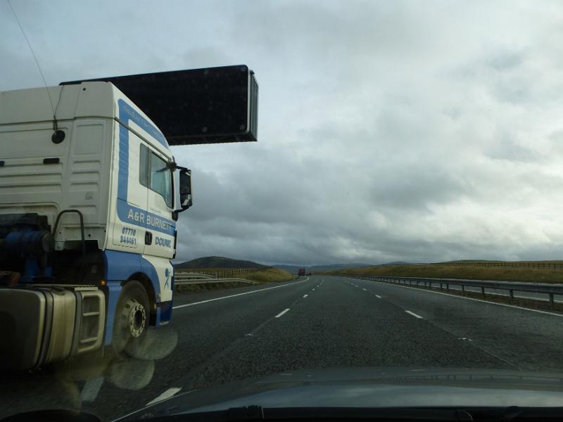 Free Stock Photo: Truck driving along a highway taken from the perspective of a car alongside showing the cab and the open road