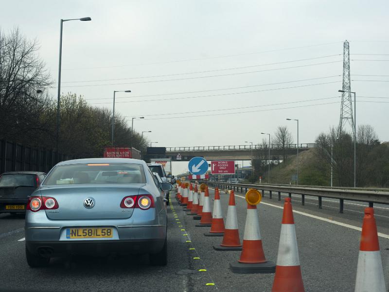 Free Stock Photo: Lane constriction on a motorway for road works with a long line of traffic cones restricting cars from using the right hand lane