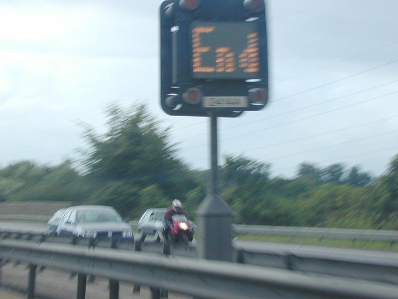 Free Stock Photo: Blurry image taken on expressway of sign that reads end as motorcycle speeds by