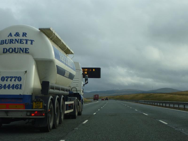 Free Stock Photo: Driver perspective passing a tanker lorry travelling on a motorway on a rainy overcast day approaching it from behind with an open lane ahead