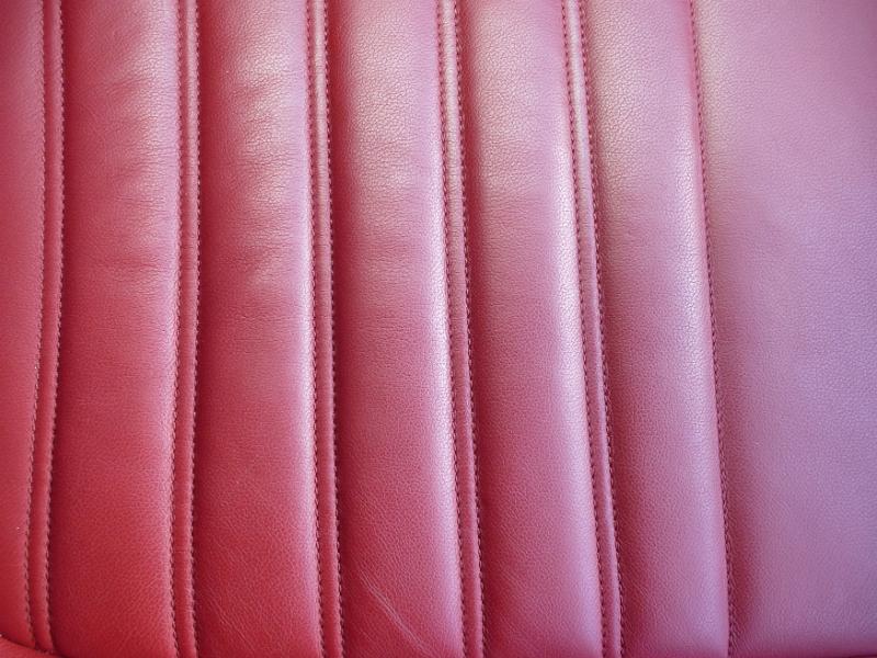 Free Stock Photo: Red leather car seat background texture wit vertical ridges and stitching in a full frame view