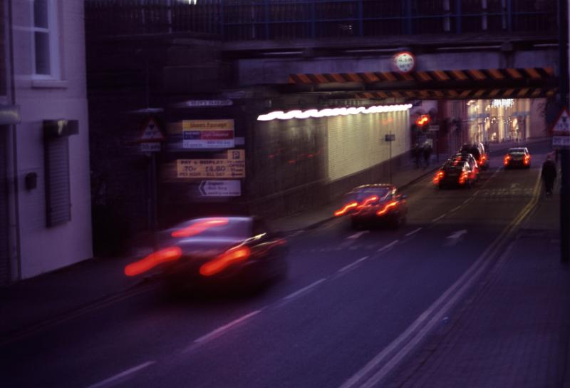Free Stock Photo: Motion blurred urban traffic driving at night under a bridge or overpass in a commercial street