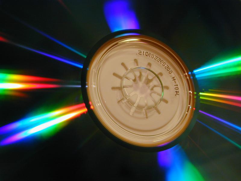 Free Stock Photo: Radiating rays of colorful vivid spectral light on a CD around the central symbol in a concept of communication and data storage