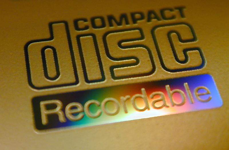 Free Stock Photo: Recordable compact disc lable close-up on yellow CD surface