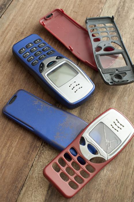 Free Stock Photo: Assorted old mobile phone covers or cases in red blue and black for push button phones, some broken and damaged