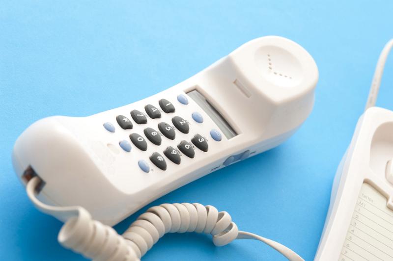 Free Stock Photo: White telephone instrument off the hook with the handset lying upside down revealing the keypad in a communication concept
