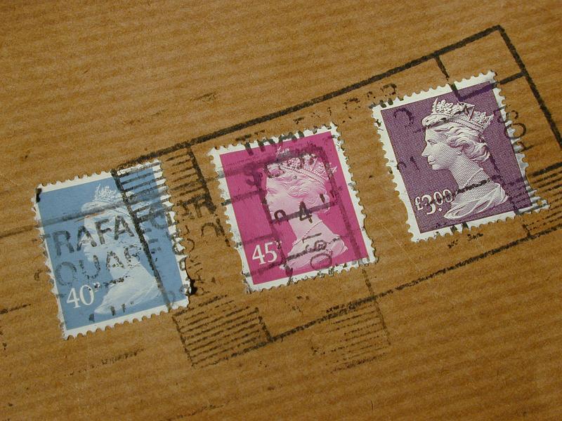 Free Stock Photo: Cancelled British postal stamps on a brown paper parcel showing the fee for dispatching the package through the mail