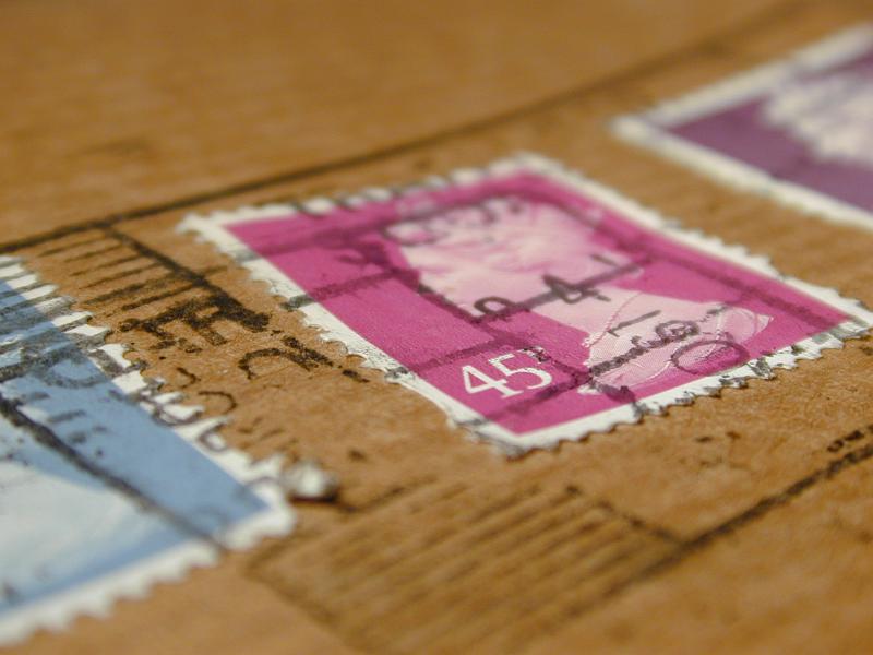 Free Stock Photo: Low angle view of a cancelled British postage stamp on a brown paper wrapping with focus to the price of 45p