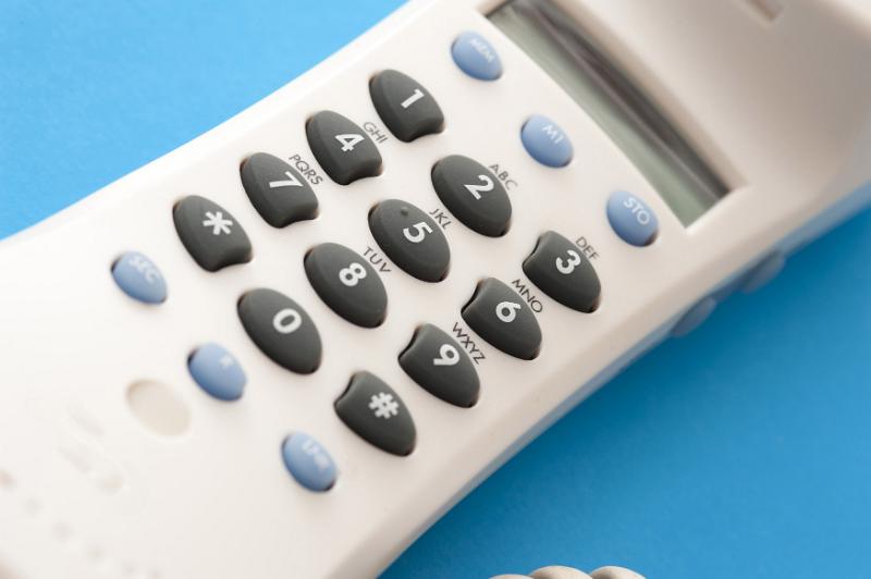 Free Stock Photo: Keypad or dial pad on a white plastic terrestrial telephone handset viewed close up over a blue background in a communications concept