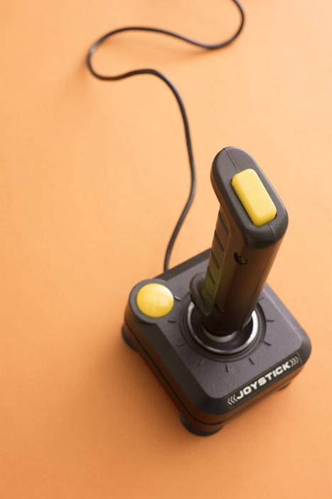 Free Stock Photo: Retro wired computer gaming joystick with yellow buttons for playing video games viewed from above in an entertainment concept