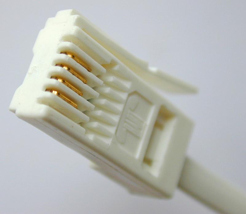 Free Stock Photo: A close up of a white phone cable plug isolated on a plain background.