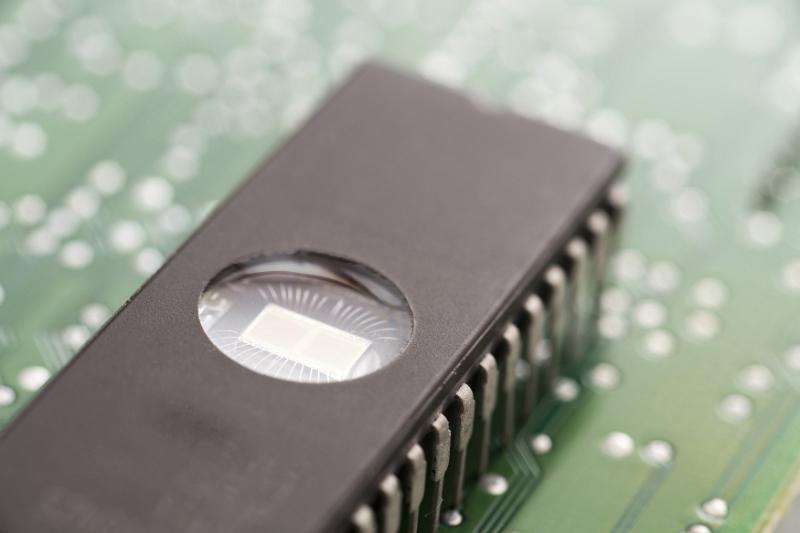 Free Stock Photo: Eprom memory chip with round window on the back installed on electronic circuit board, close-up view from high angle