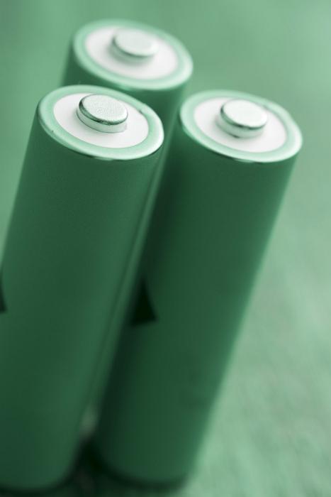 Free Stock Photo: Three green rechargeable batteries stand with positive side up, isolated on a blurred green background - green energy concept