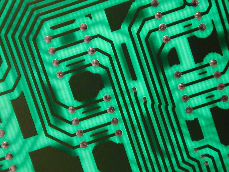 Free Stock Photo: The conductive tracks and electrical wiring of a green circuit board are illuminated by back lighting.