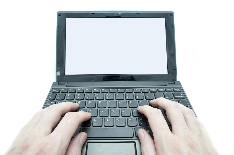Free Stock Photo: hands using a laptop computer with a blank screen