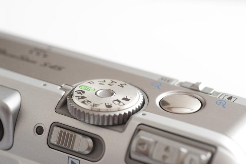 Free Stock Photo: Close up view of the controls on a compact camera with the function and program dial and shutter button isolated on white with copy space