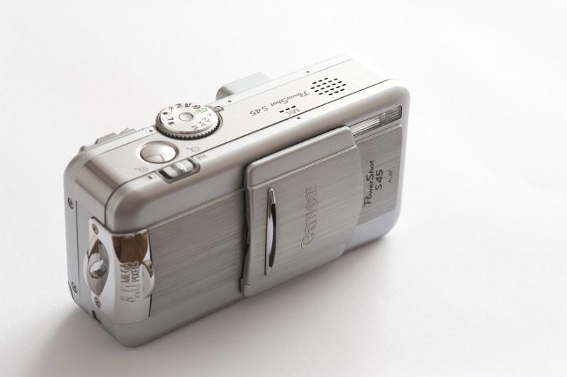Free Stock Photo: Silver compact camera with retracting lens behind a sliding cover viewed high angle on white with copy space