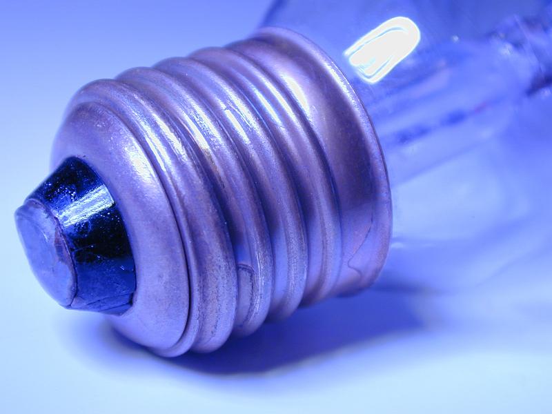 Free Stock Photo: Screw fitting on an electric light bulb viewed close up on the threads in blue light in a power and energy concept