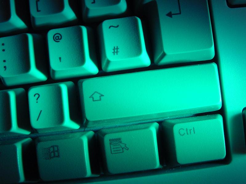 Free Stock Photo: Shift key on a white computer keyboard viewed close up from above in green light in a technology or communications concept