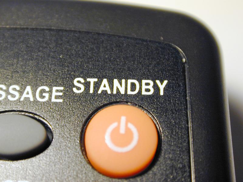 Free Stock Photo: Orange standby button on a keypad on a remote control or electronic device with a power icon and text above