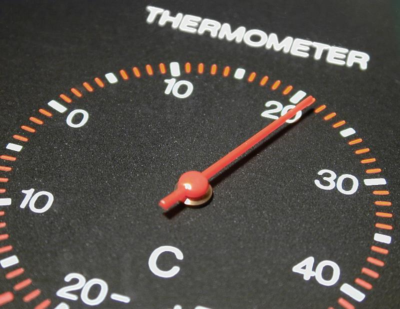 Free Stock Photo: Circular black thermometer gauge marked in degrees Celsius with the red needle pointing to 21 degrees in a close up view