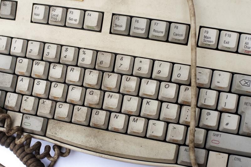 Free Stock Photo: Old filthy dirty grungy white computer keyboard with cord viewed close up from above in a communication concept