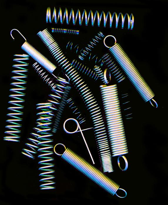 Free Stock Photo: Collection of assorted metal steel springs or connectors on black viewed from overhead