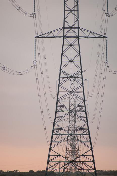 Free Stock Photo: Electric pylon with high voltage cables distributing electricity on the grid viewed at sunset or sunrise against a pale pink orange sky