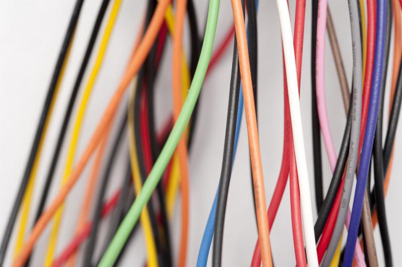Free Stock Photo: Jumble of colorful electric wires with plastic covering in the colors of the rainbow over a white background in an electronics and technology concept
