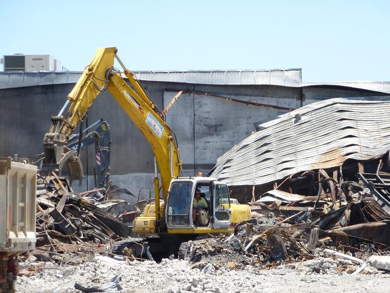 Free Stock Photo: Heavy duty machinery moving tangled metal on a building site after demolition of an old commercial building
