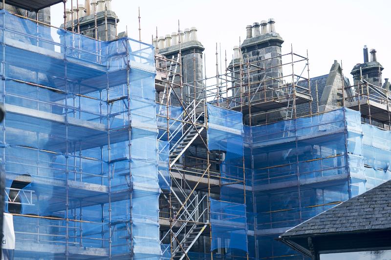 Free Stock Photo: Scaffolding and protective sheeting on a building site covering a large building during repairs and maintenance