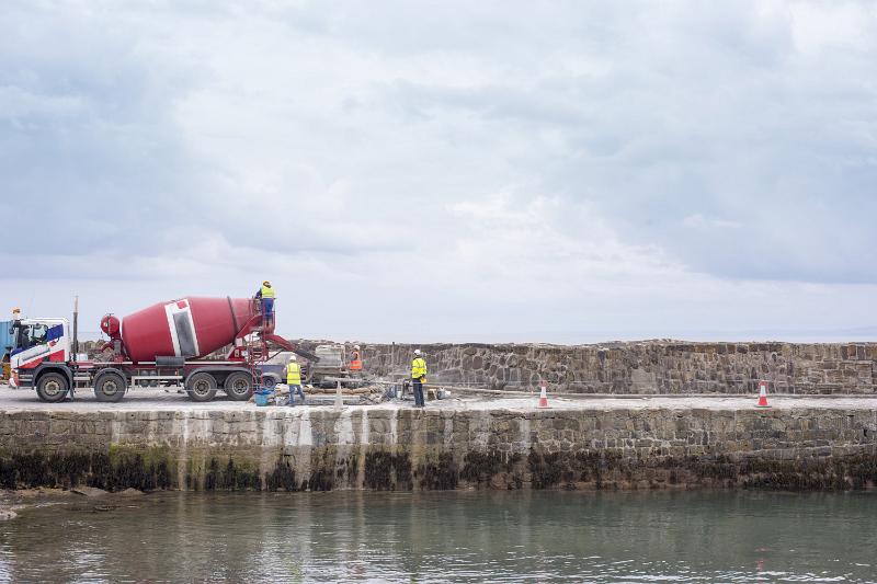 Free Stock Photo: Cement mixer truck with workmen on a concrete wharf or quay in a concept of marine construction under a cloudy sky