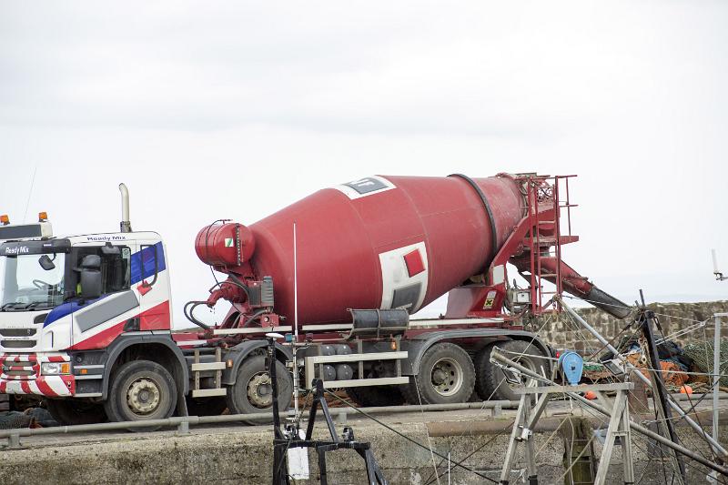Free Stock Photo: Large red cement mixer truck parked on a concrete wall or quay during construction or maintenance repairs