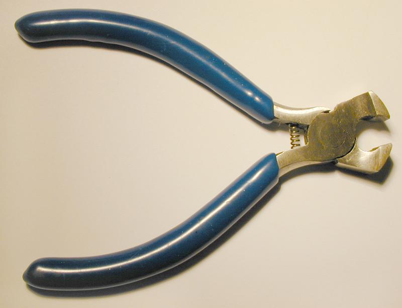 Free Stock Photo: Pair of steel cutters lying open on a white background viewed from above with copy space
