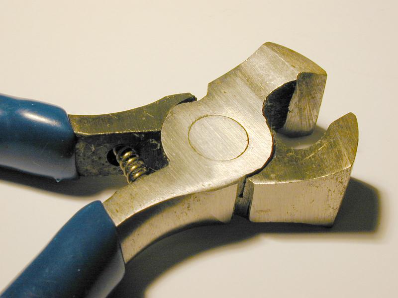Free Stock Photo: Close up on the steel jaws of a pair of cutters lying open on a white background with shadow