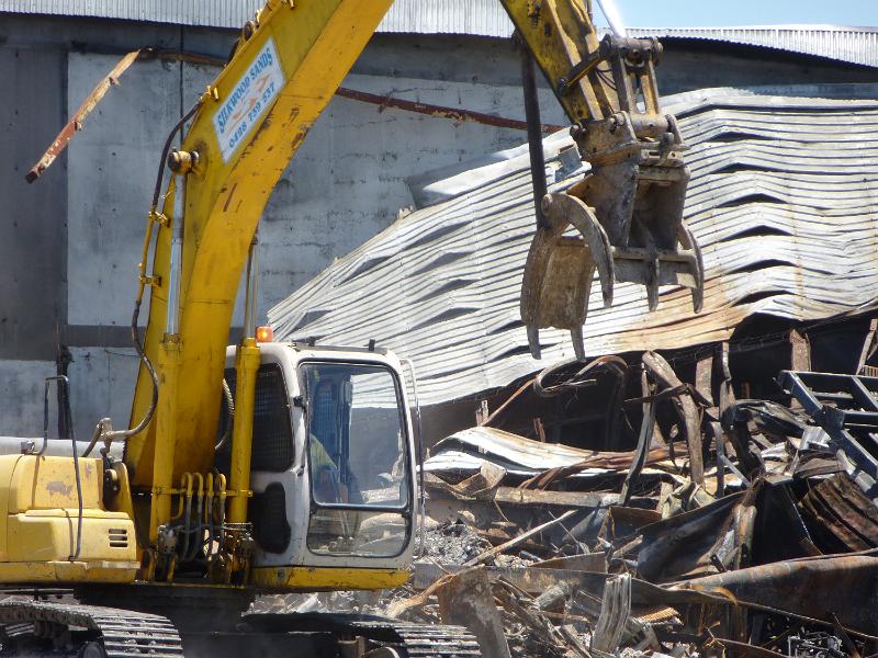Free Stock Photo: Heavy duty machinery clearing tangled metal after the demolition of a commercial building in a close up view on the jaws