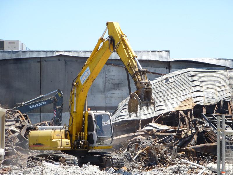 Free Stock Photo: Demolishing an old or burnt down building with heavy duty equipment excavators, sorting metal elements with manipulator