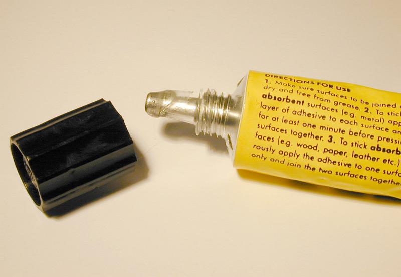 Free Stock Photo: Opened yellow tube of glue with black cap in close-up
