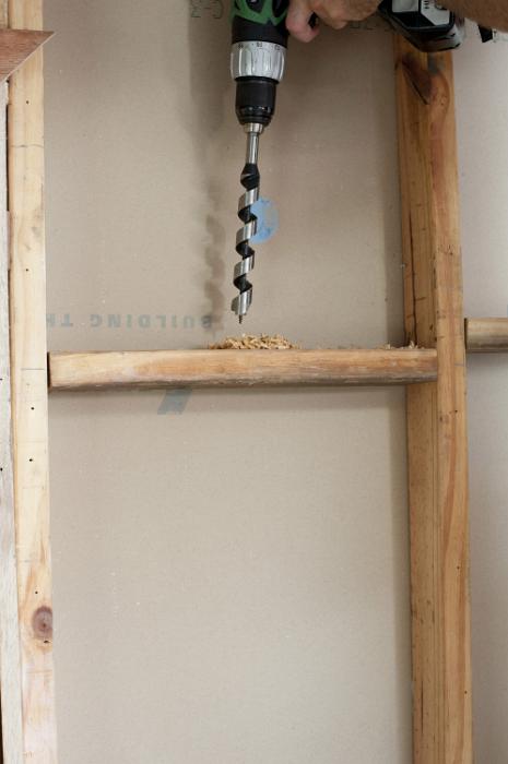 Free Stock Photo: Drilling wire hole in a stud wall of a wooden frame house with an battery drill