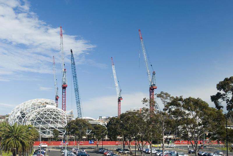 Free Stock Photo: Modern urban construction concept with large industrial cranes on the skyline of a city above domed structures