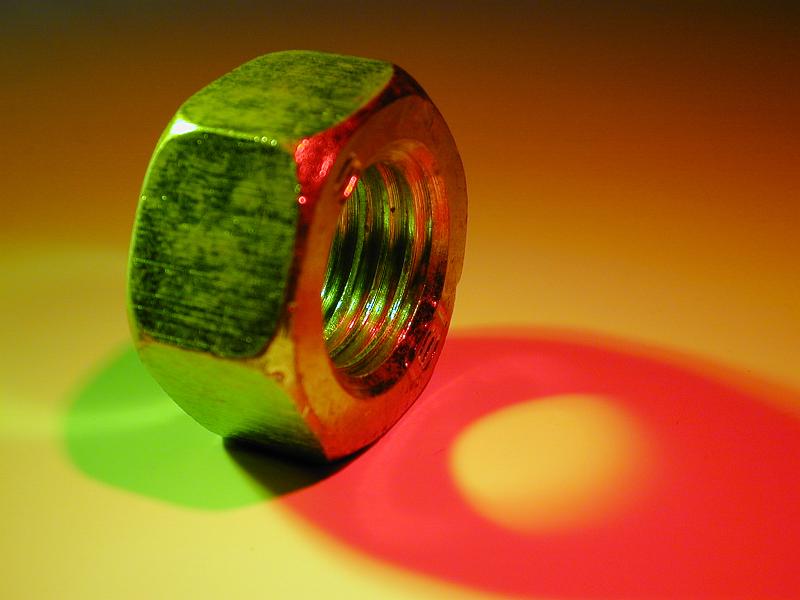 Free Stock Photo: Close-up on steel nut hardware with colorful shadows of green and red lighting