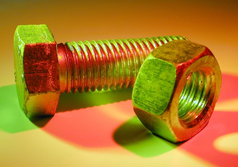 Free Stock Photo: Close up detail of a threaded steel bolt and nut in colorful lighting casting a red shadow with copy space