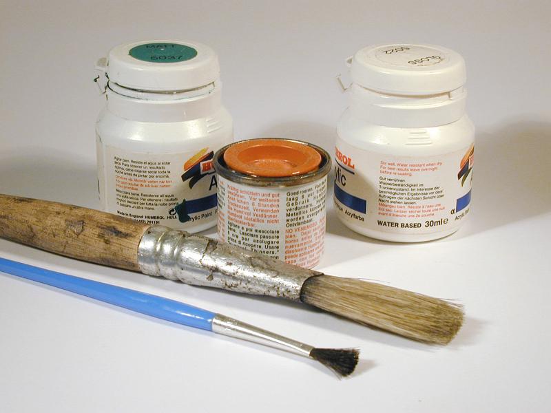 Free Stock Photo: Small cans of paint with two paintbrushes of assorted sizes in a handicraft and decorating concept
