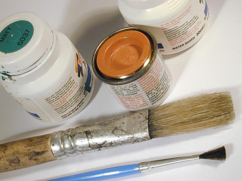 Free Stock Photo: Small cans of paint and clean brushes of different sizes viewed in close-up on white background