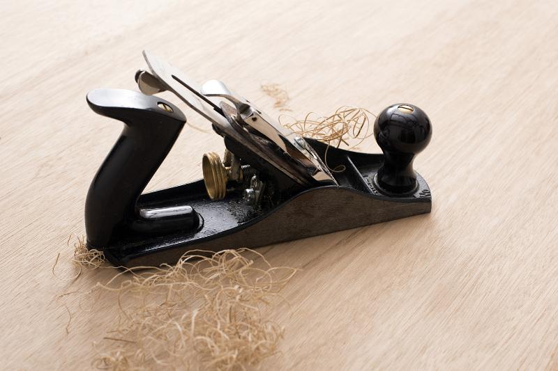 Free Stock Photo: Classic carpenters plane on wooden surface with shavings, viewed in close-up
