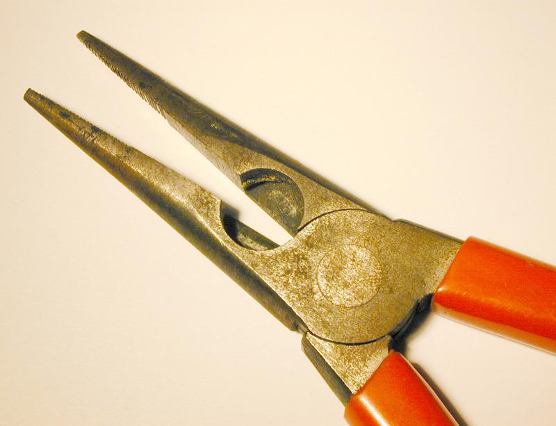 Free Stock Photo: Pair of pliers with open jaws on white in a close up partial view from above