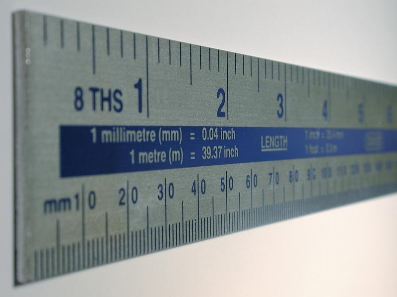 Free Stock Photo: Dual scale rule with inches and centimetres at an oblique angle view over white with copy space